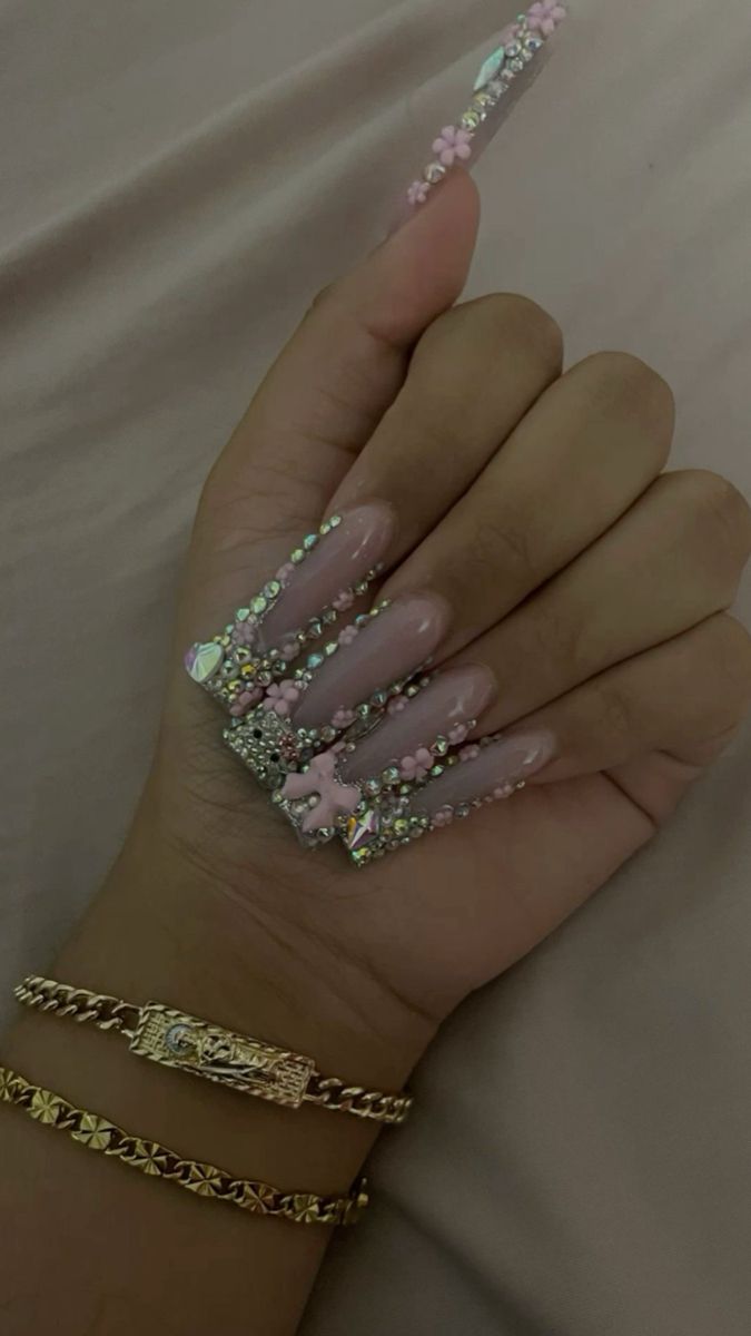 Elegant Rhinestone and Flower Accented Long Nails in Soft Pink for Stunning Occasions.