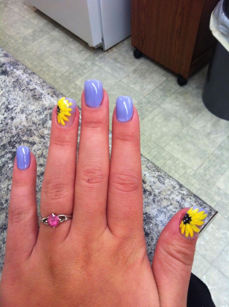 Playful Pastel Lavender Nail Design with Cheerful Sunflower Accents and Delicate Pink Ring.