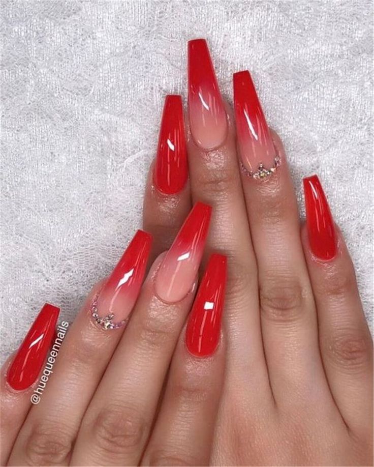 Elegant Red Ombre Nails with Tapered Shape and Sparkling Embellishments.