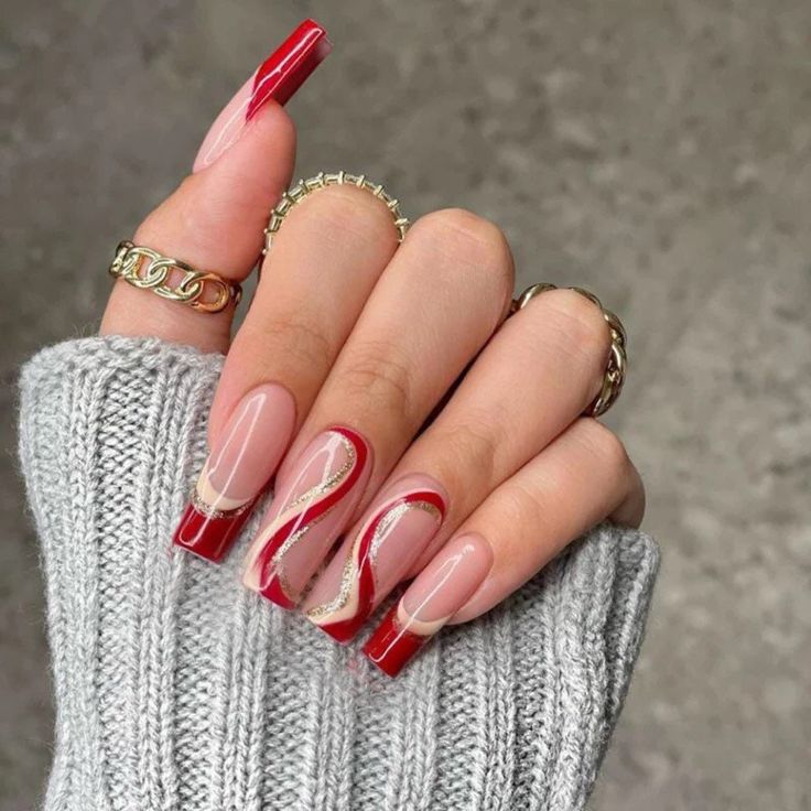 Chic Nude and Bold Red Nail Design with Elegant Swirls and Geometric Patterns.