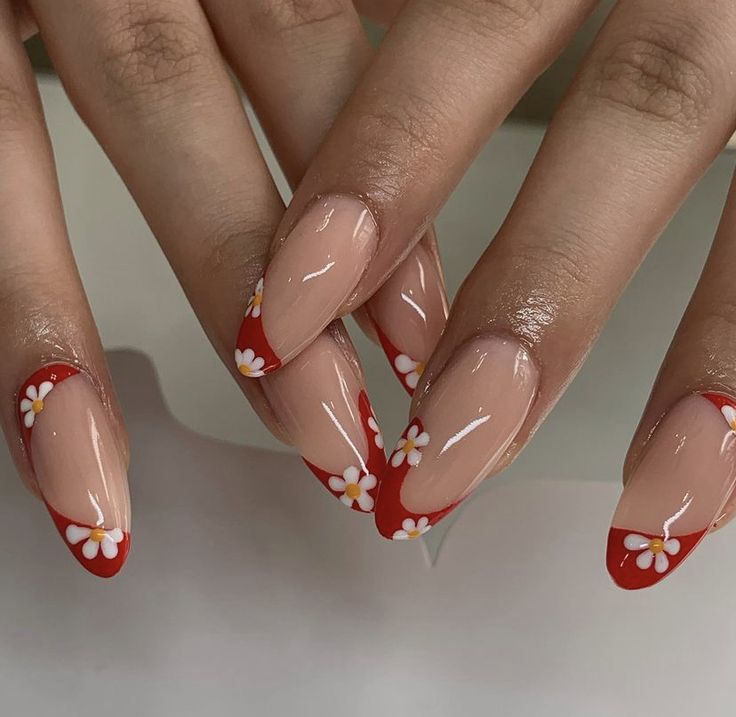 Elegant Nude Nails with Striking Red Tips and Delicate Floral Accents.