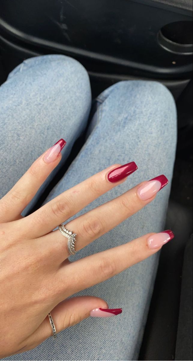 Trendy Almond-Shaped French Manicure: Deep Red Tips on Soft Pink Base.