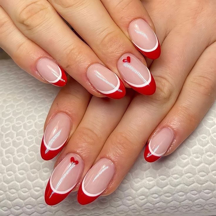 Romantic French Tip Nail Design with Red Hearts and Delicate Accents.