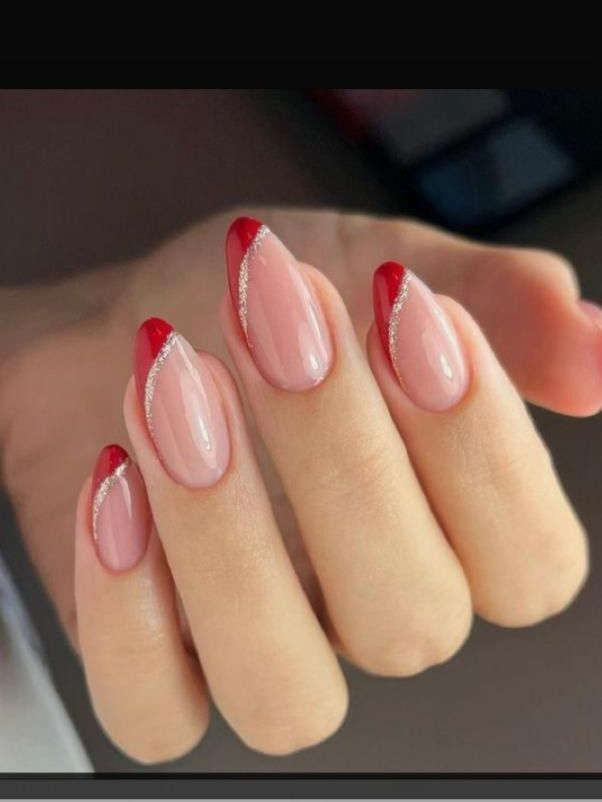 Chic Elegant Nail Design: Subtle Nude Base with Striking Red Tips and Curved Silver Stripes.