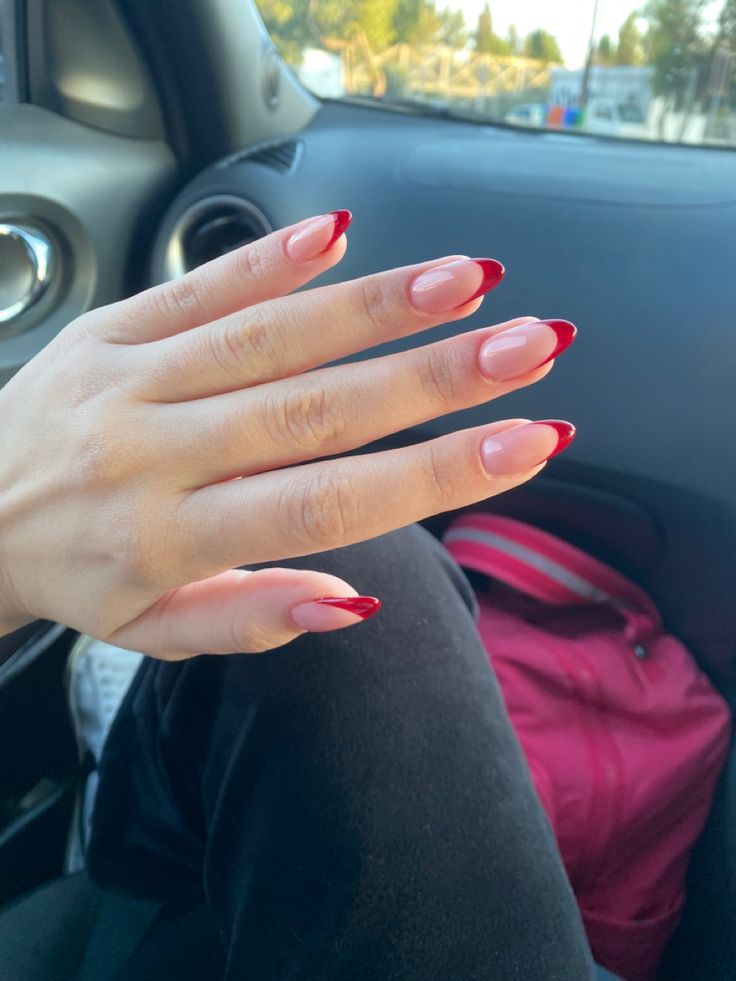 Sophisticated French Tip Nail Design with Bold Red Tips on a Nude Base.