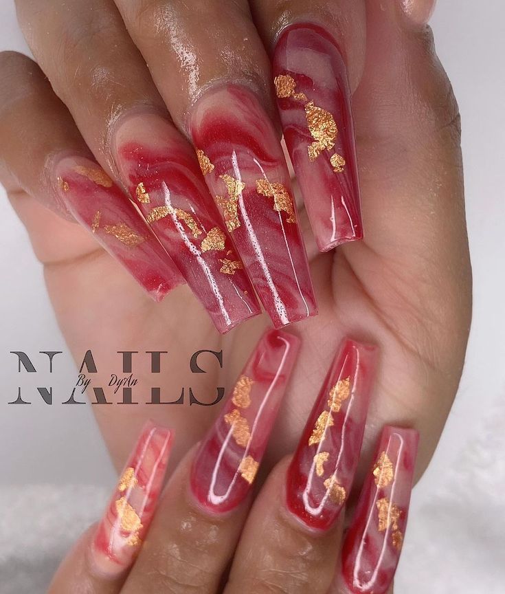 Luxurious Elongated Tip Nail Design with Vibrant Red Marble and Gold Foil Accents.