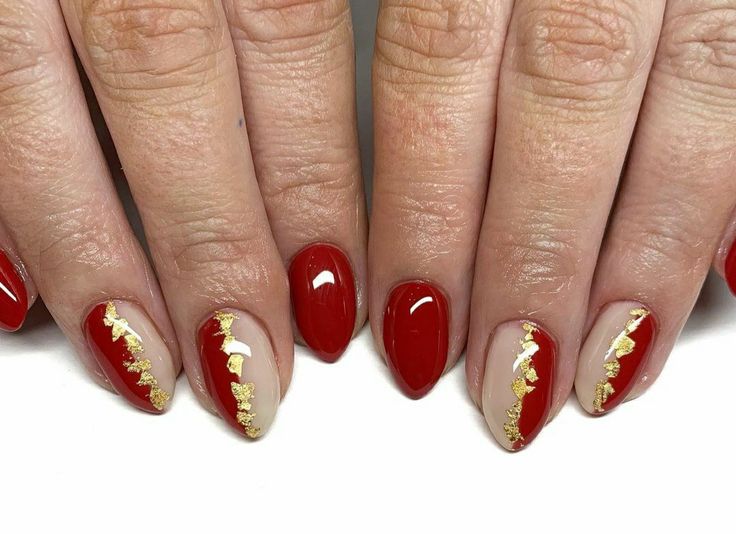 Chic Nail Design: Bold Red and Neutral Tones with Luxurious Gold Accents.