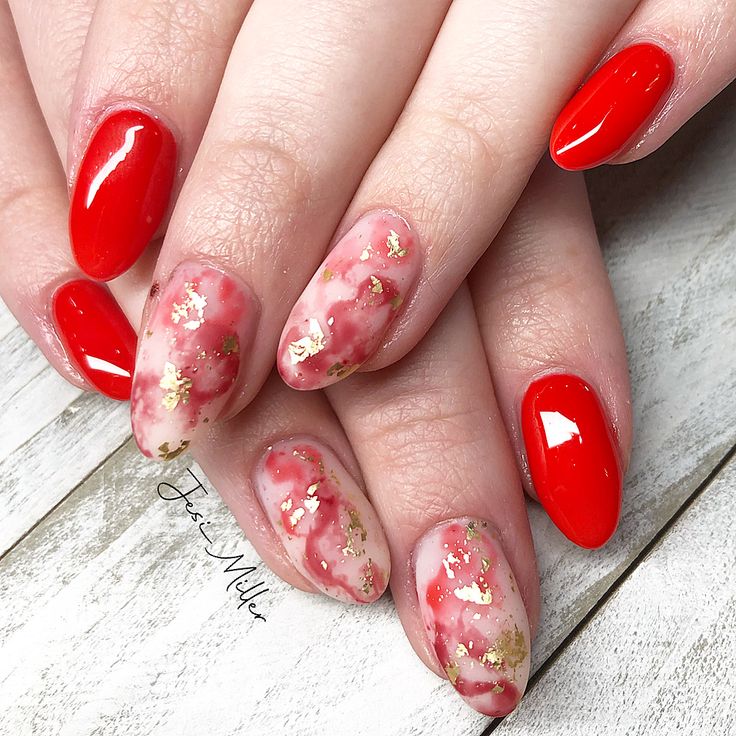 Playful yet Sophisticated Nail Design: Bold Red and Soft Pink with Luxurious Gold Flakes.