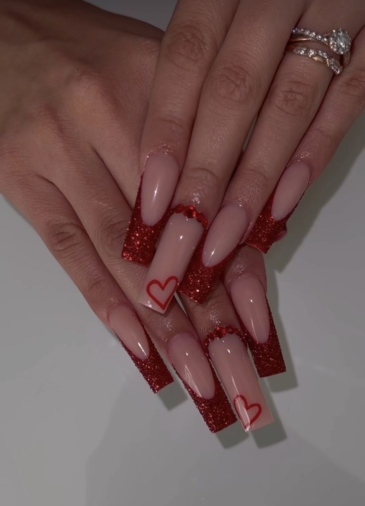 Chic Nail Art: Nude and Red Elegance with Heart Accents for Festive Occasions.