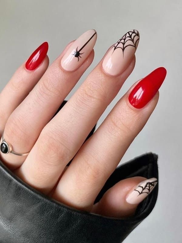 Playful Spooky Nail Design: Bold Red and Soft Nude with Spiderweb Patterns.