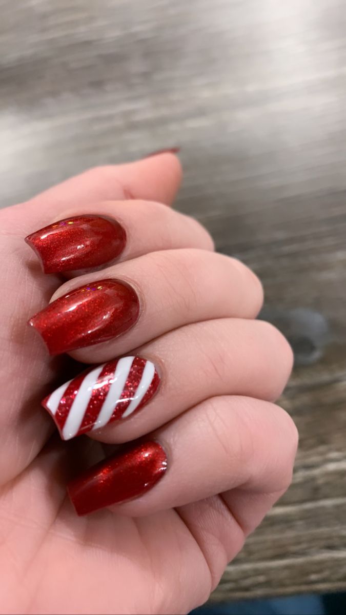 Vibrant Holiday-Themed Sparkling Red Nails with Festive Candy Cane Accent.