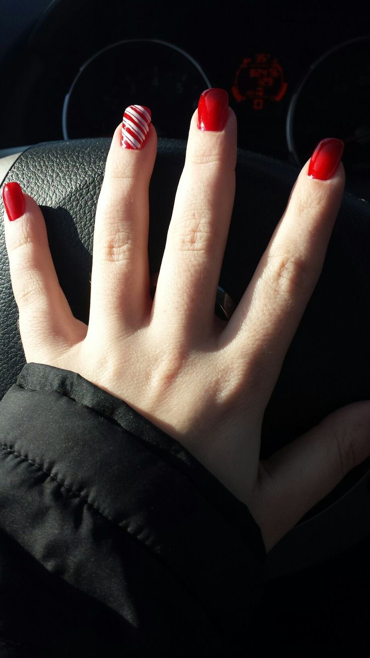 Vibrant Red Nail Design with Candy Cane-Inspired Accent for Festive Elegance.