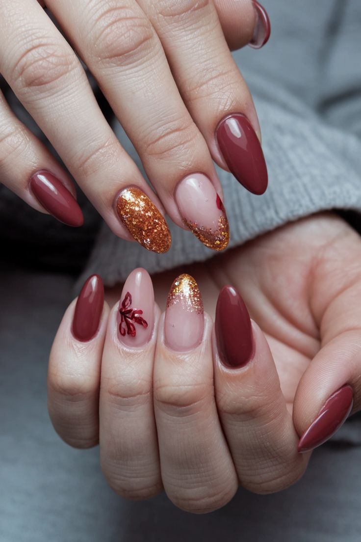 Sophisticated Nail Design: Rich Burgundy, Gold Accents, and Elegant Floral Touches.