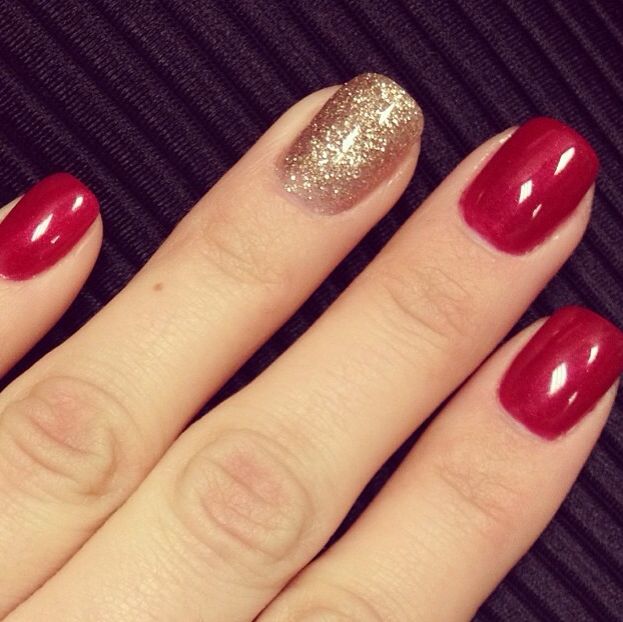 Chic Elegant Manicure: Bold Red with a Shimmering Gold Accent Nail.