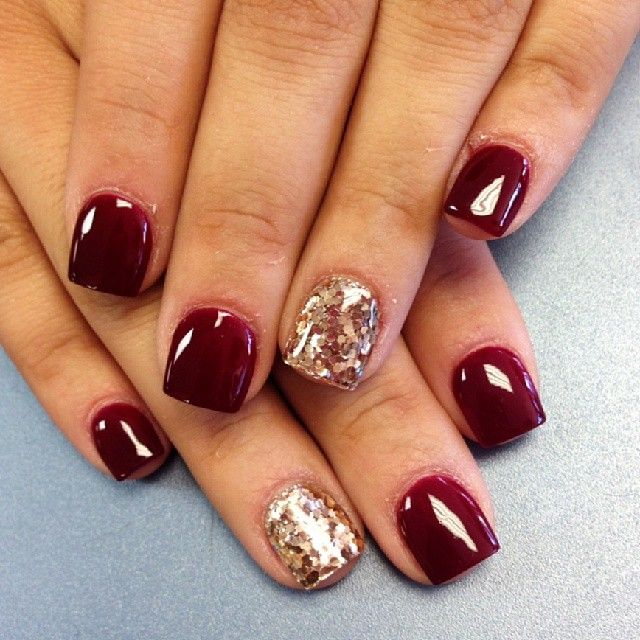 Chic Deep Burgundy Nail Design with Glamorous Gold Glitter Accent.