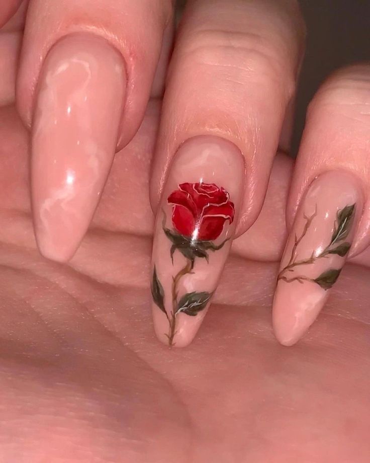 Elegant Nail Design: Soft Nude Base with Intricate Red Rose and Leafy Vine Details.