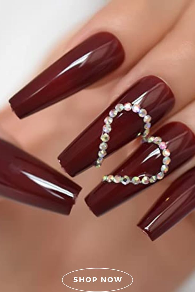 Sophisticated Burgundy Nails with Heart Design and Rhinestones for Glamorous Occasions.