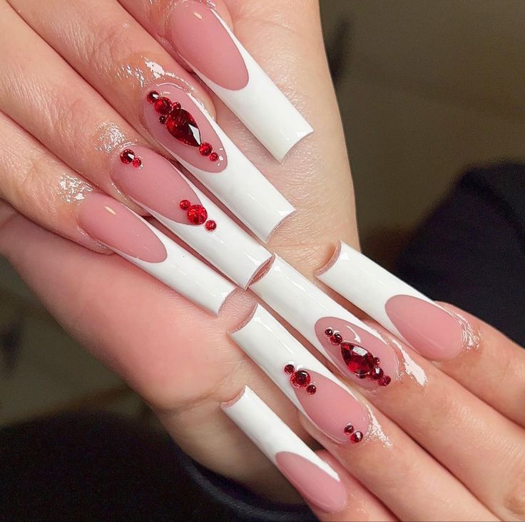 Elegant Nude and White Nail Design with Heart Cutouts and Sparkling Red Gem Accents.