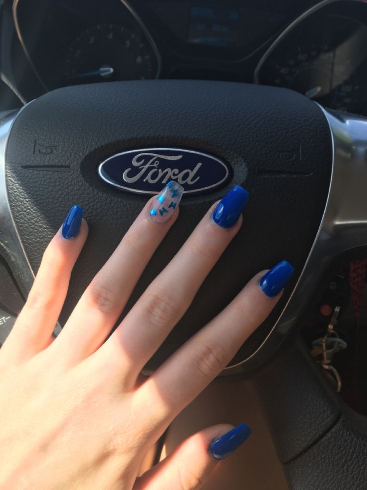 Chic Vibrant Blue Nails with Playful Accent Design Create Striking Contrast Against Steering Wheel.