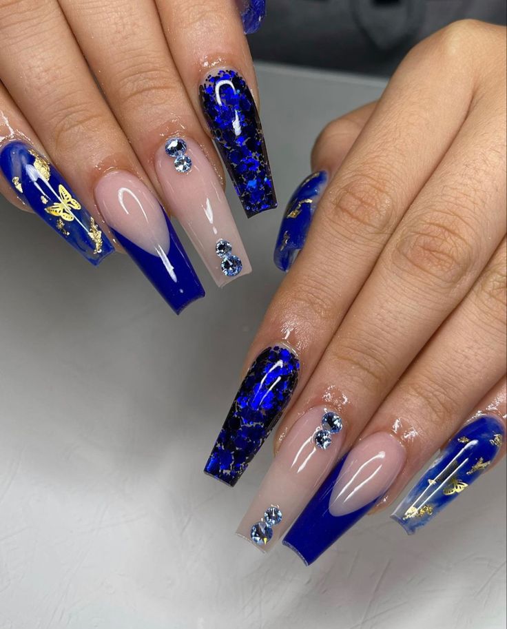 Luxurious Deep Blue Nail Design with Intricate Details and Glamorous Accents.