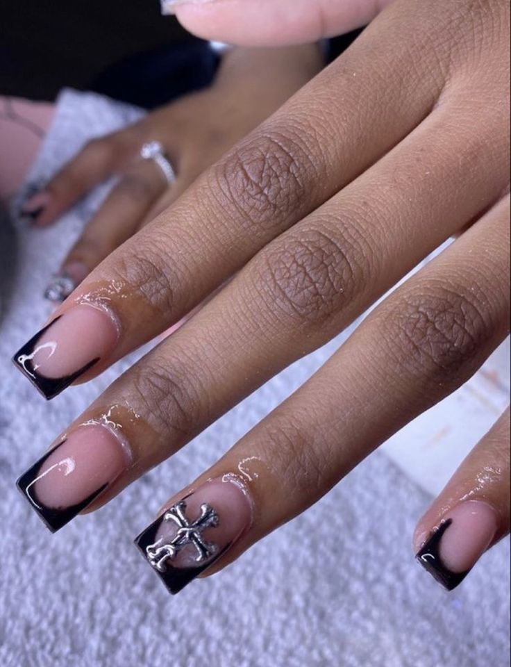 Chic French Tip Nail Design with Edgy Black Tips and Silver Cross Charm