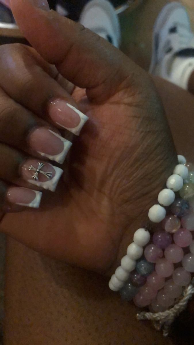 Chic French Tip Manicure with Glamorous Silver Charm and Beaded Bracelets.