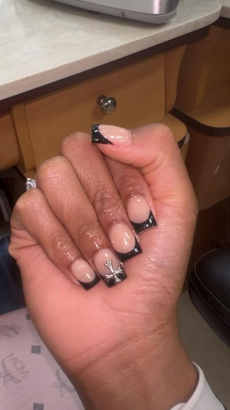 Sophisticated Nude Nail Design with Striking Black Tips and Intricate Silver Accents.