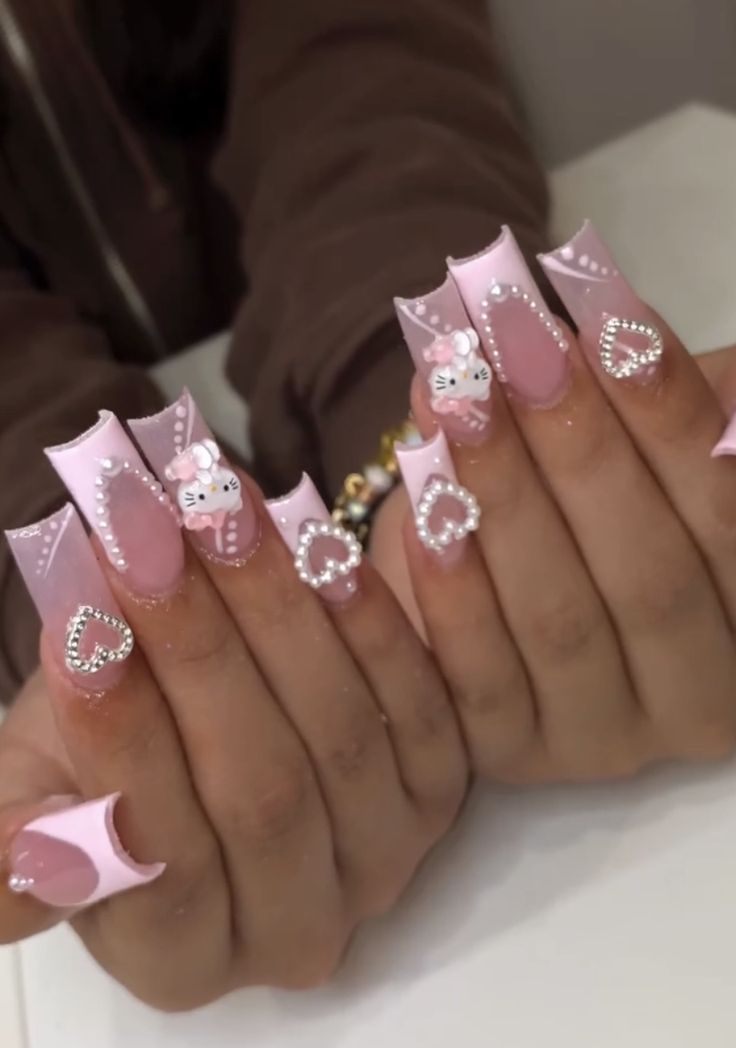 Whimsical Pink Glossy Nail Design with Elongated Tips and Charming Embellishments.