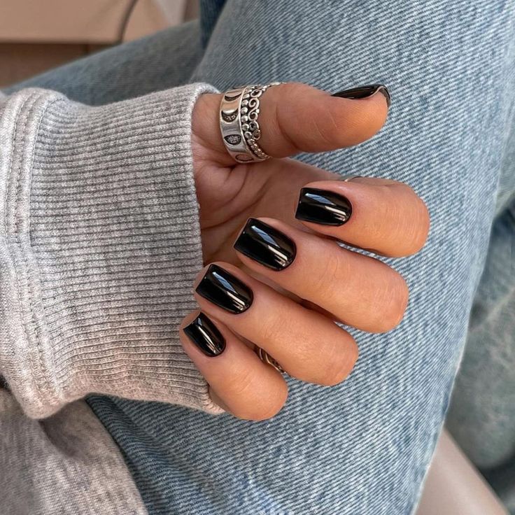 Chic Contrast: Glossy Black Nails Enhance Casual Elegance with Gray Sweater.