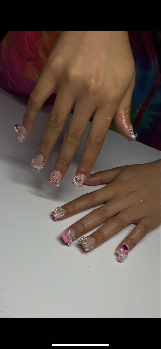 Elegant and Playful Delicate Nail Design with Soft Pinks and Intricate Embellishments.