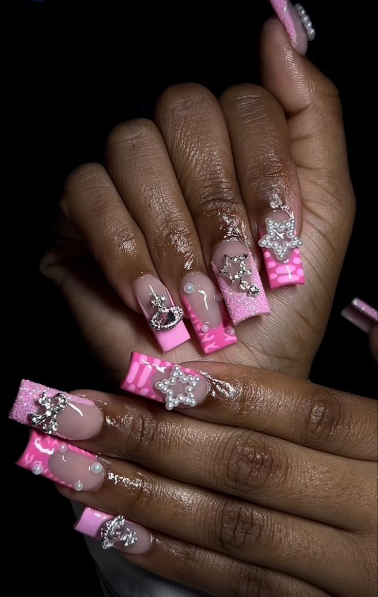 Vibrant Pink Glamorous Nail Design with Sparkling Rhinestones and Star Embellishments.