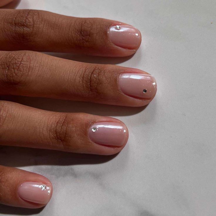 Elegant Minimalist Nail Design with Soft Pink Base and Subtle Rhinestone Embellishments.