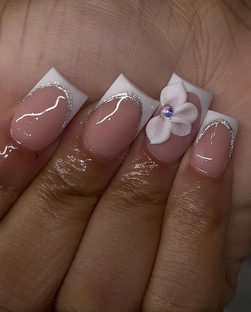 Chic Soft Pink and White Nail Design with Silver Accents and Floral Charm.