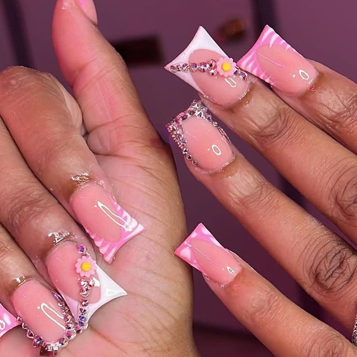 Elegant Nude and Pastel Pink Nail Design with Geometric Shapes, Floral Accents, and Sparkling Rhinestones.