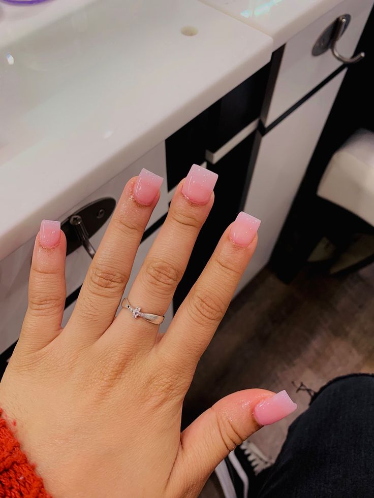 Elegantly Chic: Glossy Pink Ombre Square Nails with Silver Ring.