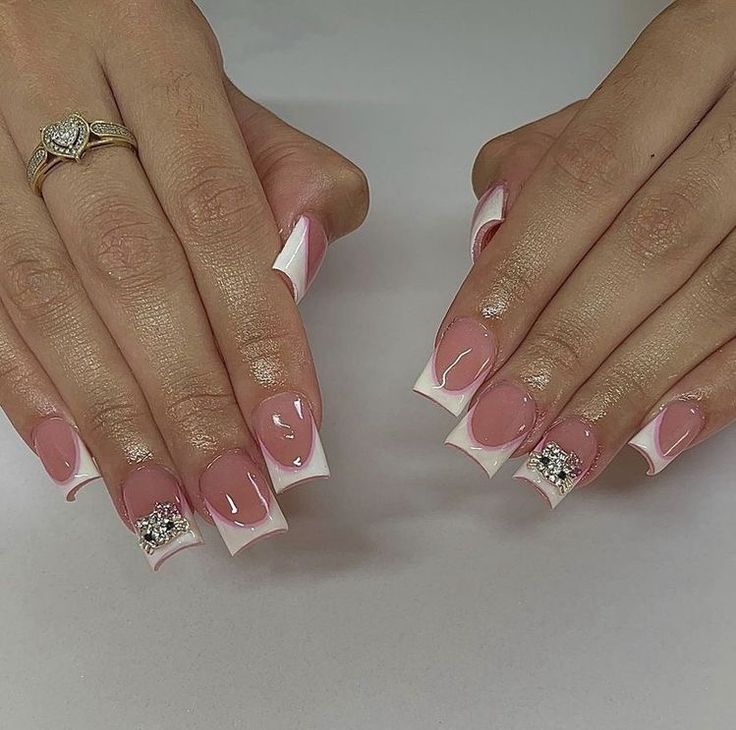 Chic French Tip Nails: Soft Pink Base with Glamorous White Tips and Sparkling Embellishments.