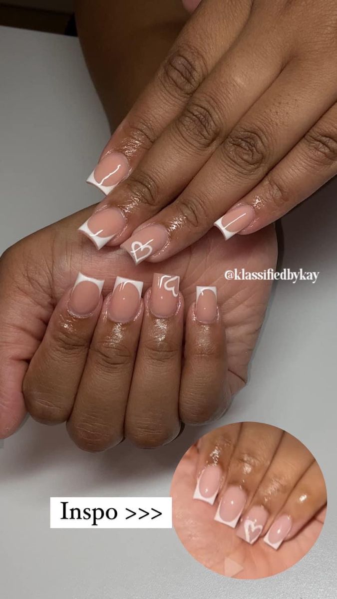 Chic Nude and White French Tip Nail Design with Playful Heart Motifs.