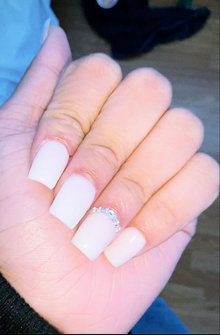 Chic White Nails with Sparkling Rhinestone Accents for a Glamorous Look.