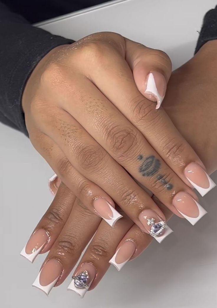 Sophisticated Nude and White Nail Design with Sparkling Accents.