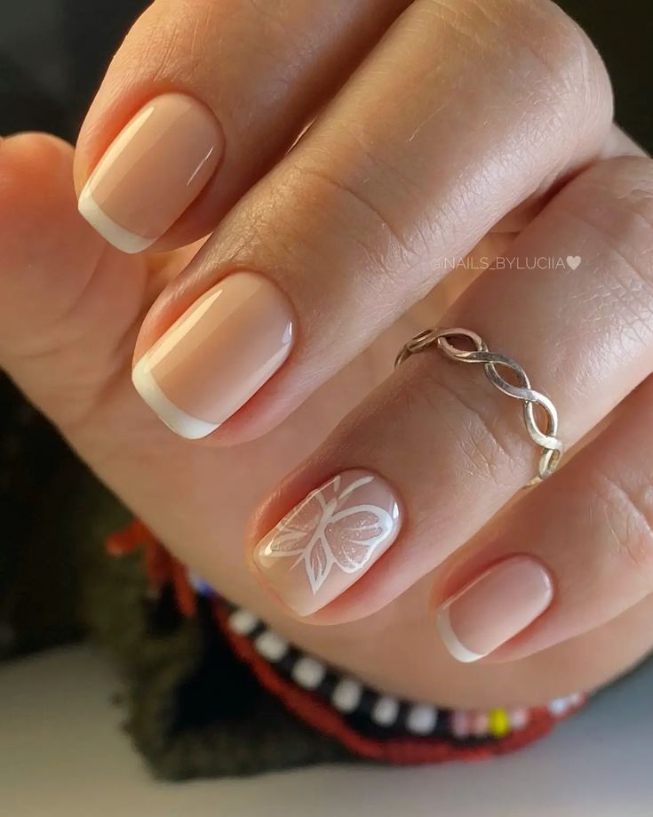 Refined Soft Nude French Tips with Whimsical Butterfly Accent Nail Design.