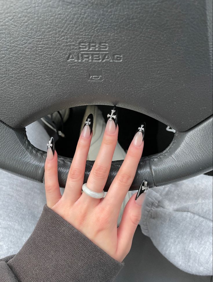 Elegant Gradient Nude Nails with Edgy Black Tips and Silver Star Accents.