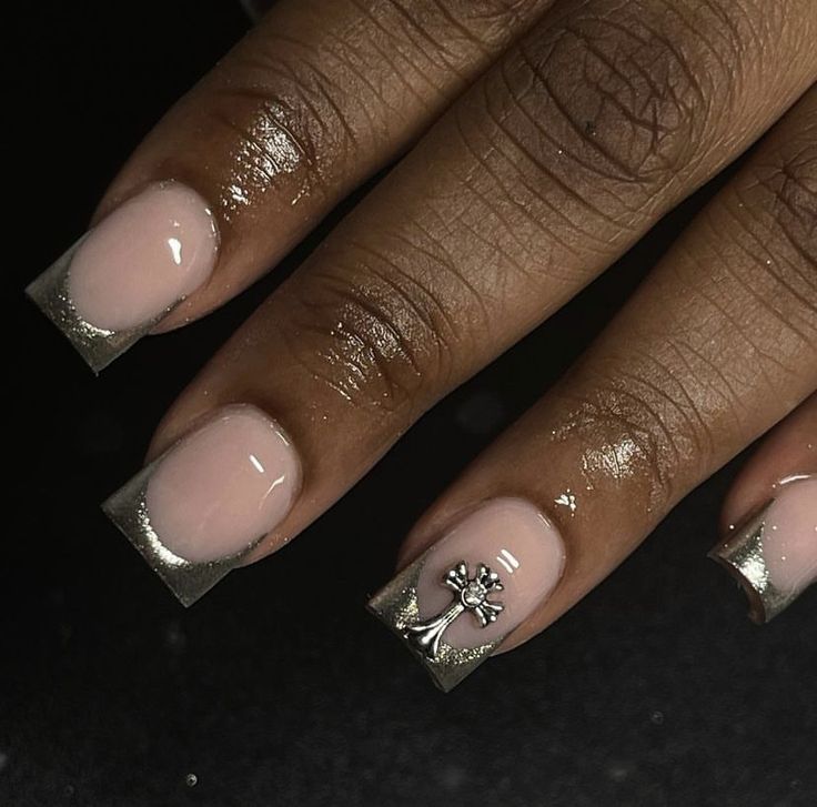 Sophisticated Nail Design: Soft Pink Base with Metallic Silver Tips and Intricate Charm Art.