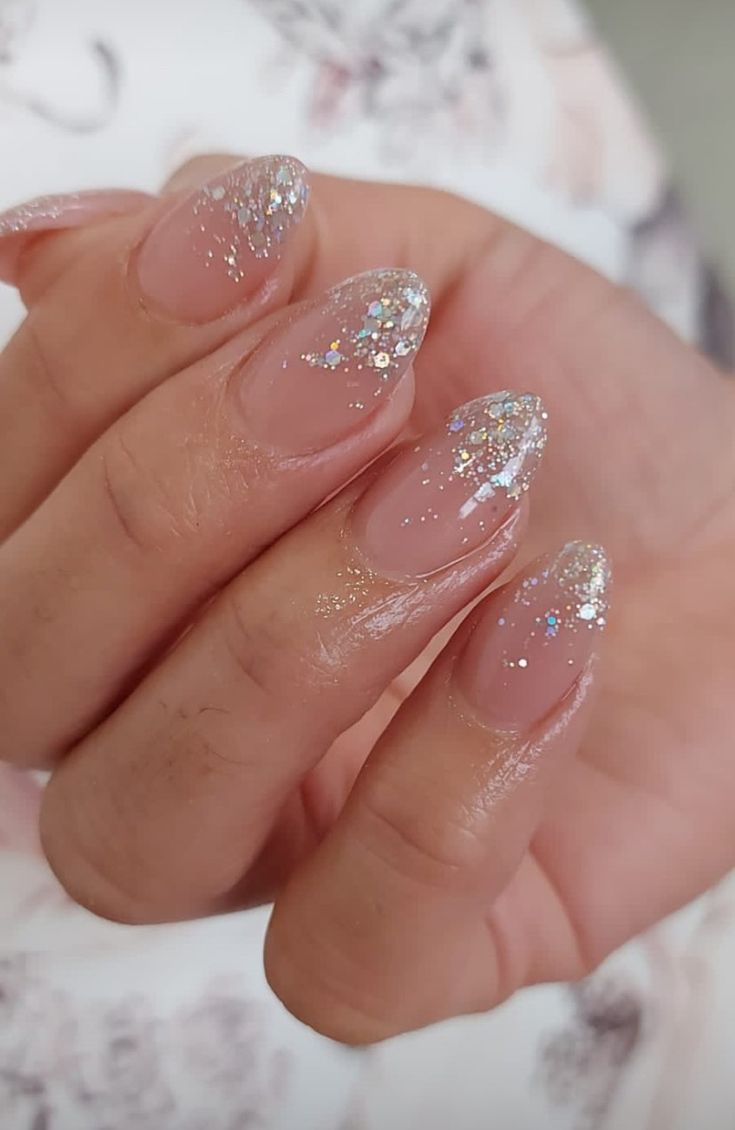 Elegant Sparkling Nail Design: Nude Polish with Dazzling Glitter Tips and Iridescent Gradient