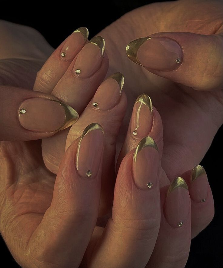 Chic Nude and Gold Nail Design with Elegant Embellishments for Modern Occasions.