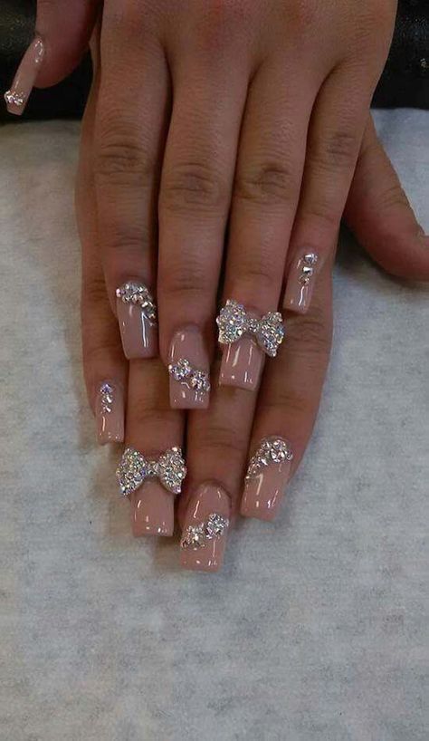 Chic Nude Nail Design with Rhinestone Accents and Charming Bow Embellishments