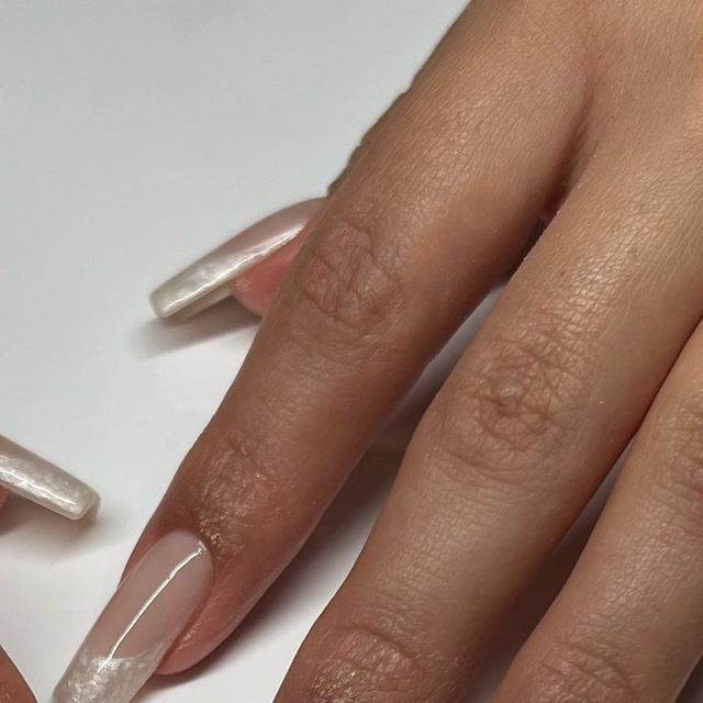 Sophisticated Nude Manicure with Subtle White Tips and Glossy Finish.