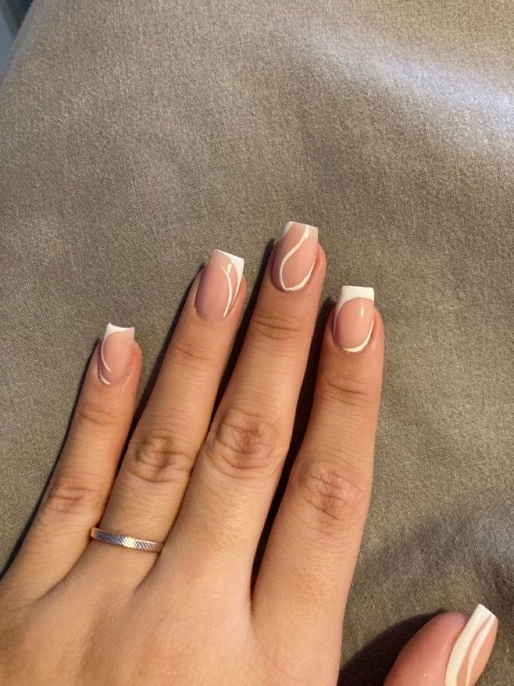 Refined Modern Manicure: Soft Nude Base with Elegant White Tips and Artistic Swirls.