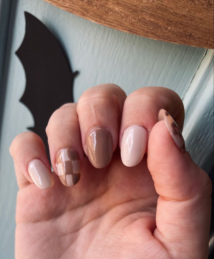 Sophisticated Nail Design: Neutral Tones, Glossy and Matte Finishes, and Checkerboard Pattern for a Modern Look.