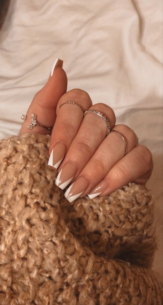 Chic Nude and White French Tip Nail Design with Elegant Silver Accents.