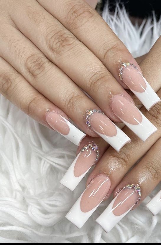 Chic Nude and White Nail Design with Glossy Finish and Rhinestone Accents.